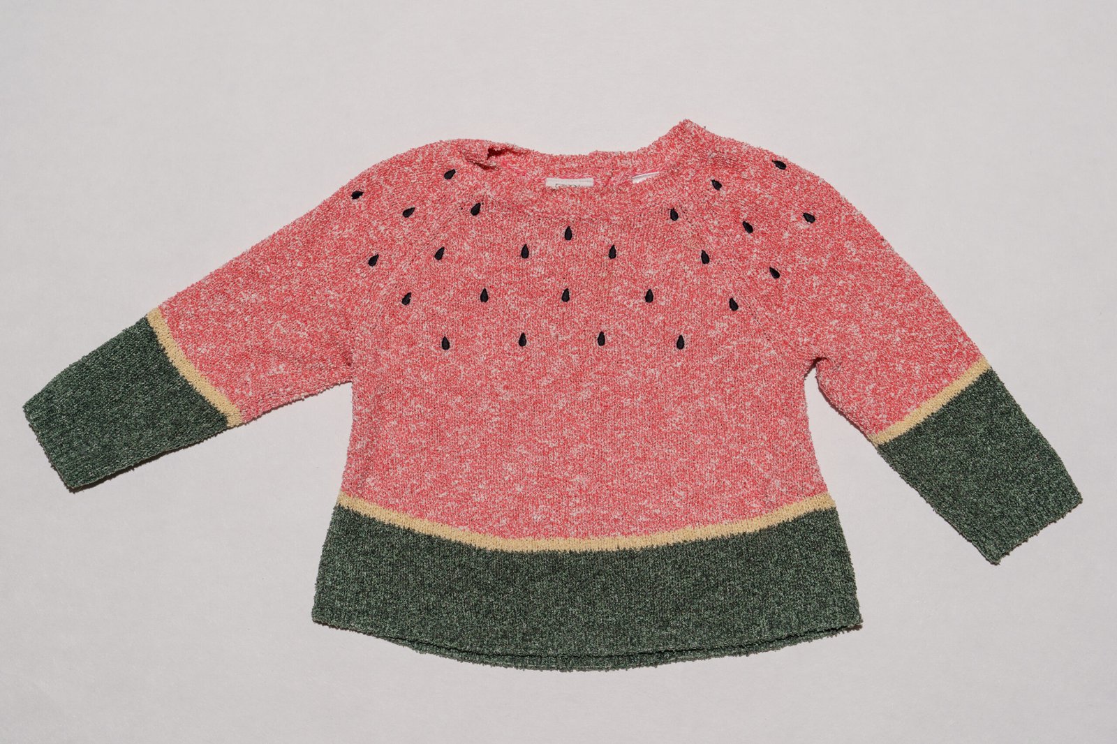 pull Zara baby motif pastèque avec des détails de graines noires sur un fond rose.